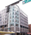 Modern building with a street sign indicating 'Larimer' in an urban setting.